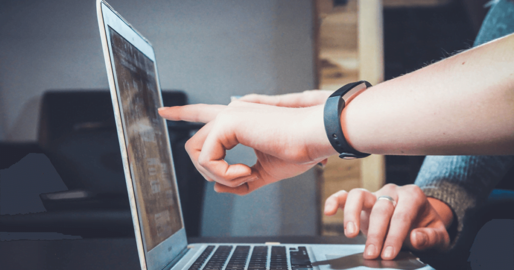 Technical SEO Audit - two people looking at the laptop - one pointing at the screen and the other using the touchpad