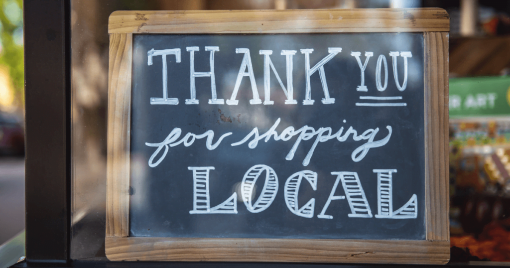 A small blackboard that has "Thank you for shopping local" written on it.